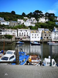 Boats moored at harbor by buildings in city