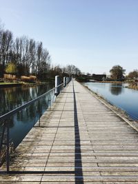 Pier over river against clear sky