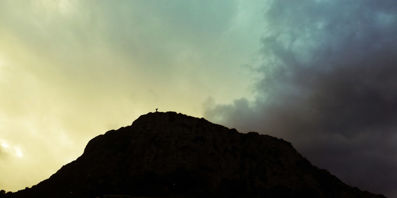 LOW ANGLE VIEW OF SILHOUETTE ROCK AGAINST SKY