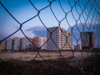 View of city seen through chainlink fence