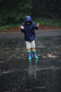 Full length of a boy standing in puddle