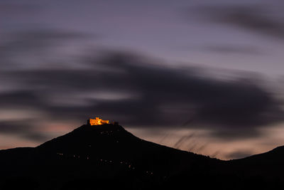Silhouette of building against cloudy sky