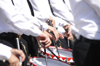 Midsection of musicians playing drum