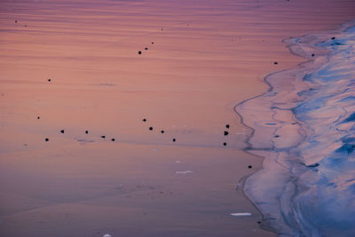 Sunset sky reflecting in frozen lake