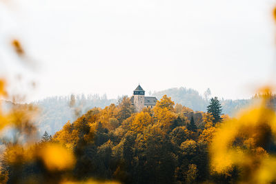 Scenic view of trees and buildings against sky during autumn
