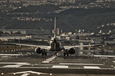 Airplane at airport runway in city