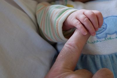 Cropped image of parent holding baby hand