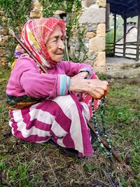 Full length of woman sitting in pink yard