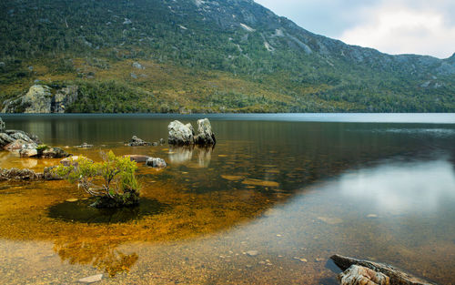 Scenic view of lake by mountain against sky