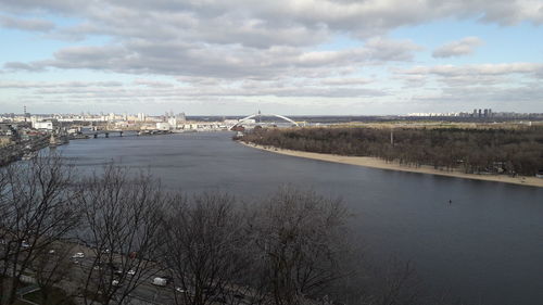 Scenic view of river by city against sky