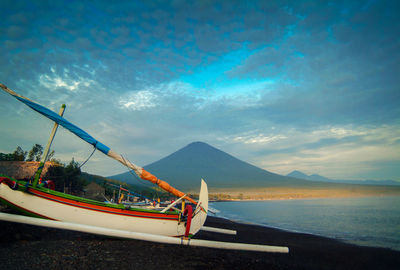 Boat moored at beach against sky