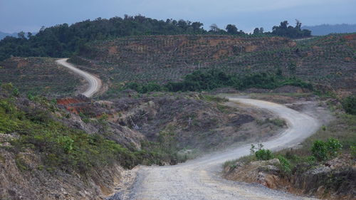 Scenic view of road by mountain against sky