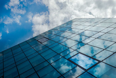 Low angle view of glass building against sky