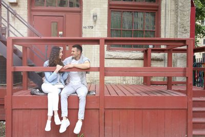 Young couple sitting on railing