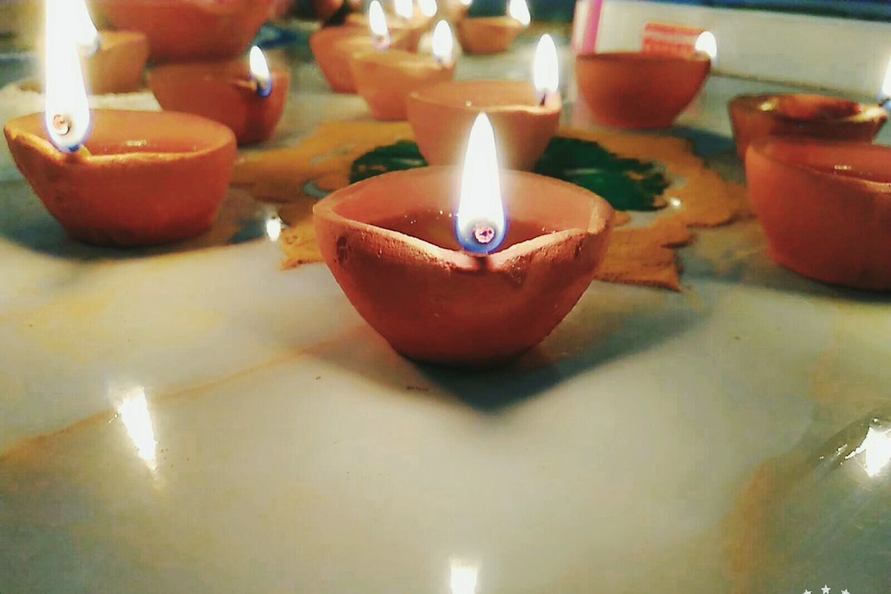 CLOSE-UP OF LIT TEA LIGHT CANDLES