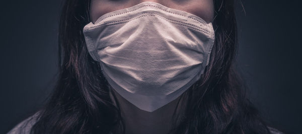 Portrait of woman against black background