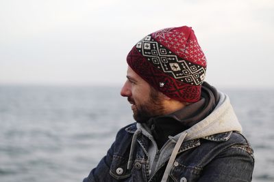 Close-up of man looking at sea against sky