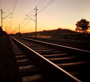 Railroad tracks against sky during sunset