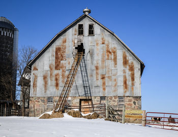 Low angle view of abandoned building against sky during winter