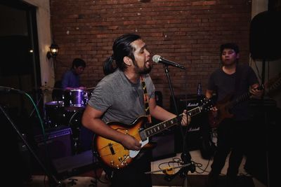 Full length of a young man playing guitar