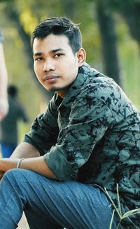 Portrait of young man sitting outdoors