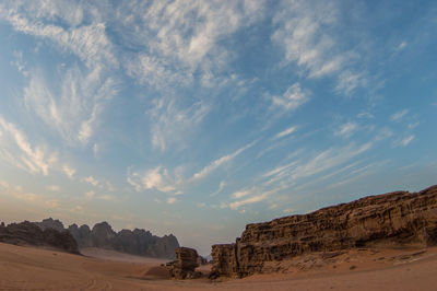 Scenic view of desert against cloudy sky