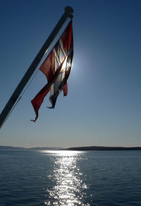 Low angle view of man jumping in sea against clear sky