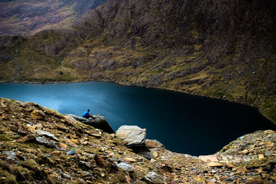 Man on rock by lake