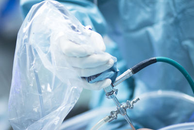 Midsection of surgeon holding medical equipment in operating room