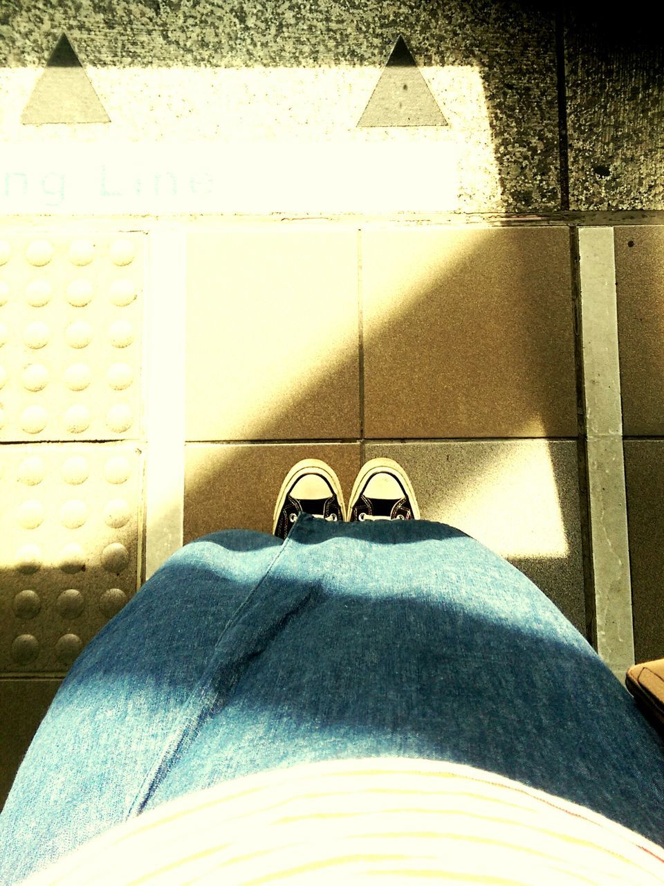 LOW SECTION OF WOMAN STANDING ON TILED FLOOR