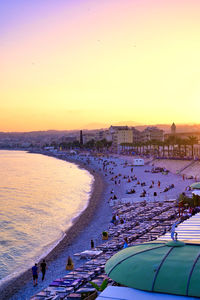 High angle view of people on beach against sky during sunset