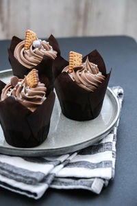 Delicious chocolate cupcakes with cream on dark background. three chocolate muffin. birthday cake 