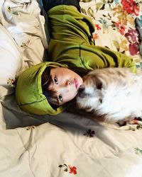 High angle portrait of dog relaxing on bed at home