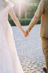 Low section of bride standing on footpath