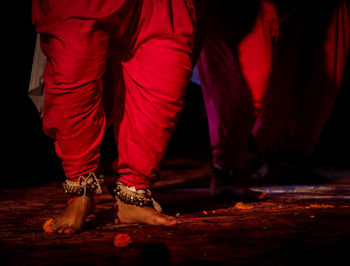 Low section of man standing in red shoes