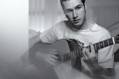 Man playing guitar at home