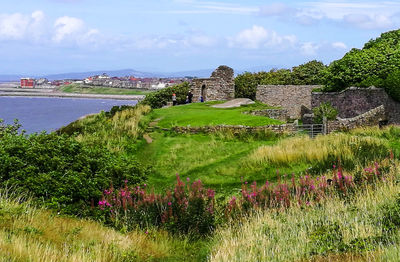 View of ruins of building against cloudy sky