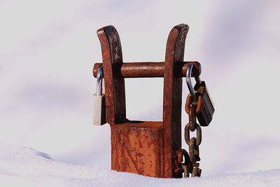 Close-up of padlocks on rusty chain against sky