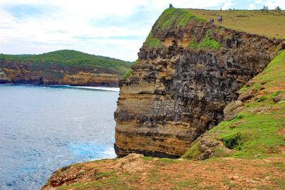 Scenic view of rock formation by sea against sky