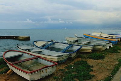 Boats moored at beach against sky