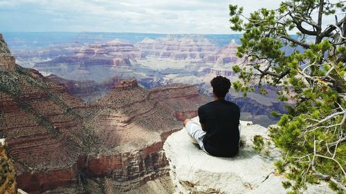 Rear view of a man overlooking woman against sky