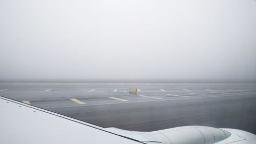 Close-up of airplane on runway against clear sky