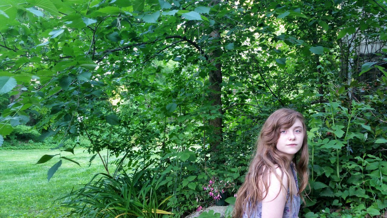 PORTRAIT OF YOUNG WOMAN IN PARK