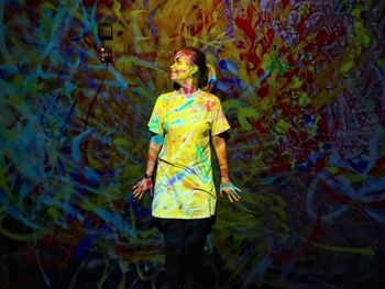 Full length of woman standing against multi colored plants