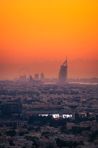 Aerial view of buildings in city during sunset