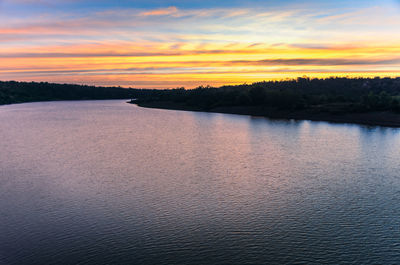 Scenic view of lake against orange sky