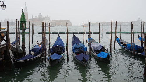 Boats moored in canal against sky