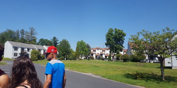 Girl standing on grass against cloudy sky