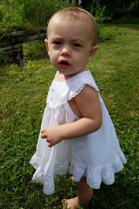 Portrait of baby girl standing on grassy field