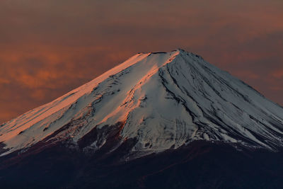 Scenic view of snowcapped mountains against dramatic sky